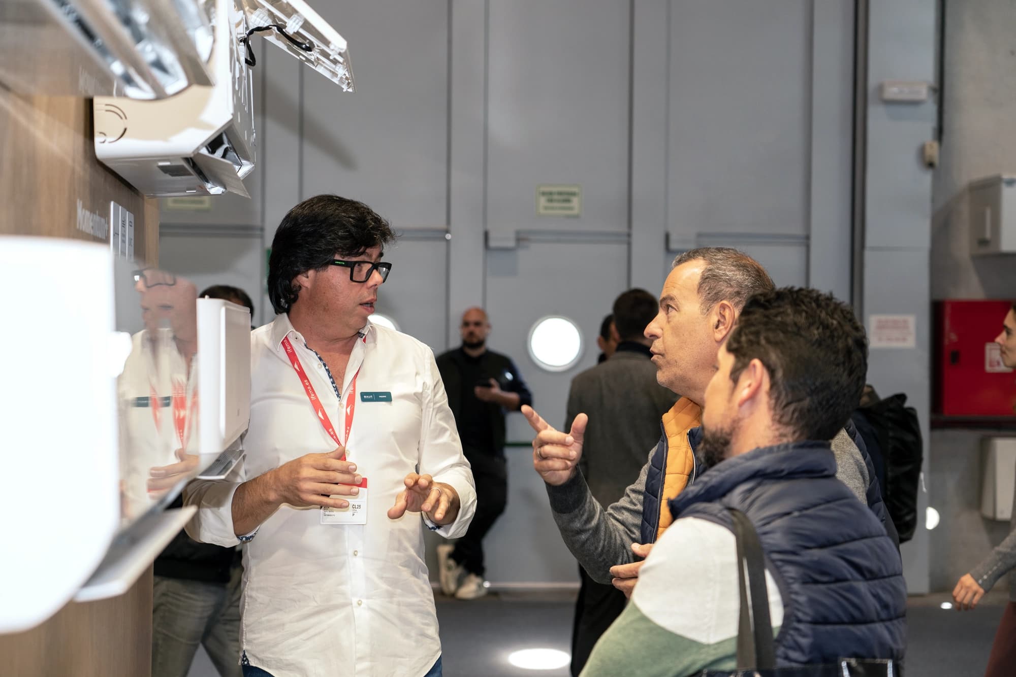 Ein BAUF Spezialist erklärt Installateuren am Messestand die Technik